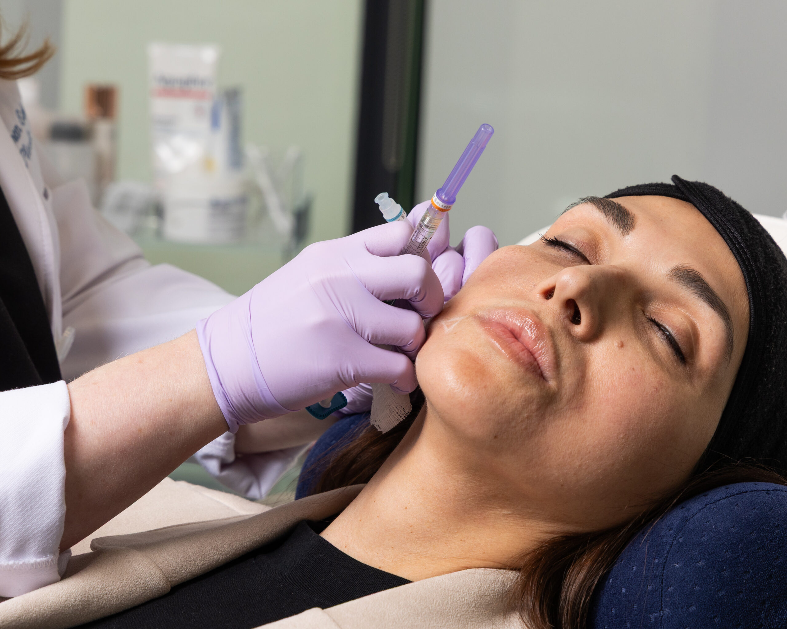 A brunette woman enjoying a Botox treatment in Alpharetta, GA at Shine Medical Aesthetics.